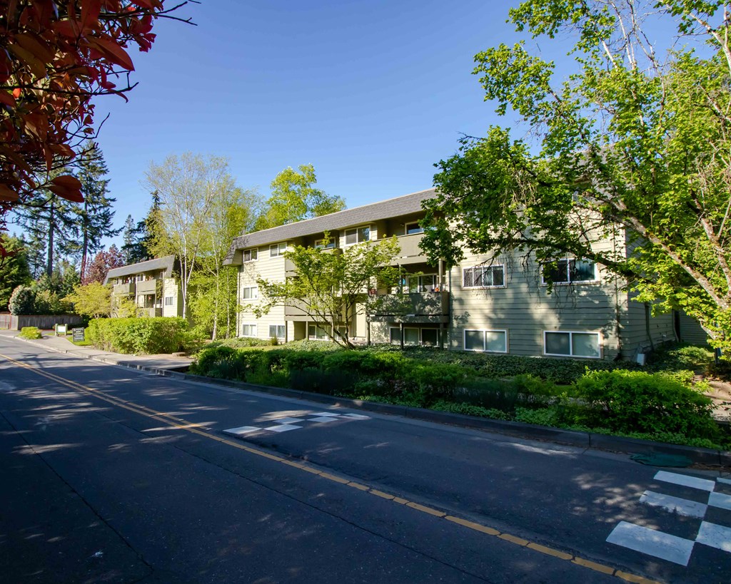 a view of the exterior of an apartment building on a street