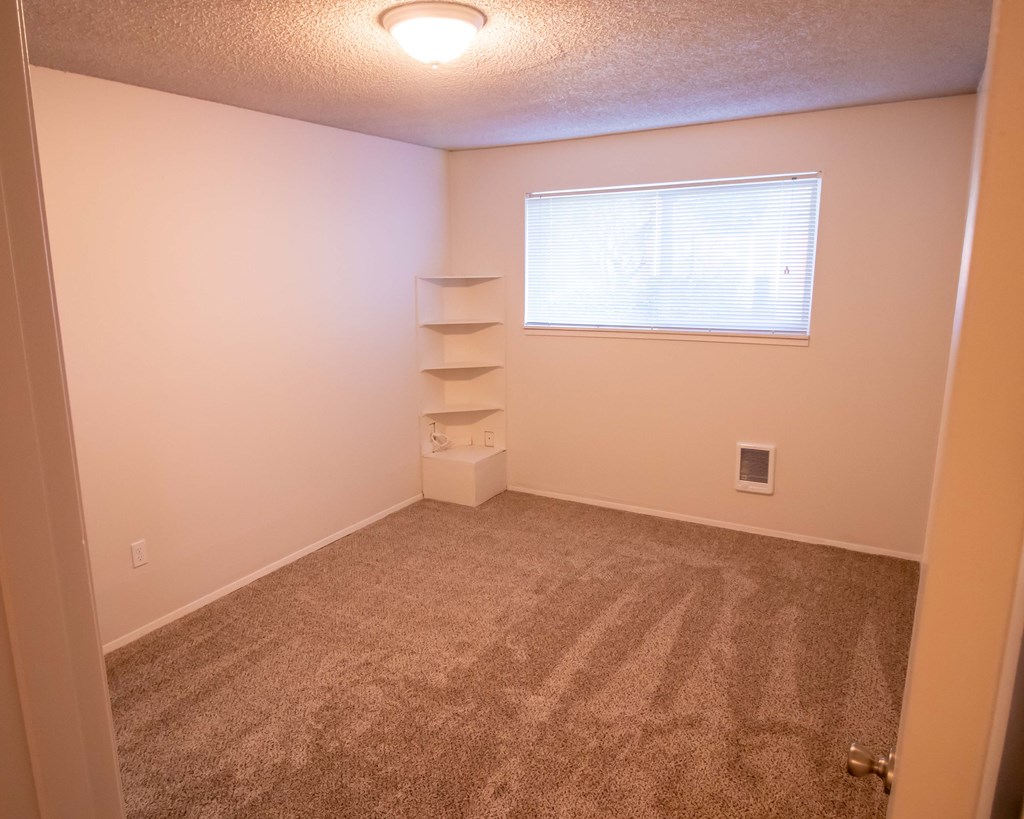 a empty room with carpet and a window