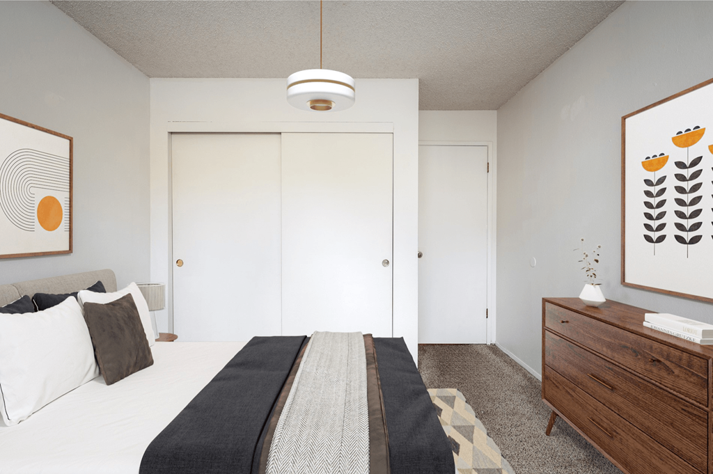 A room with a white couch and a large painting on the wall.