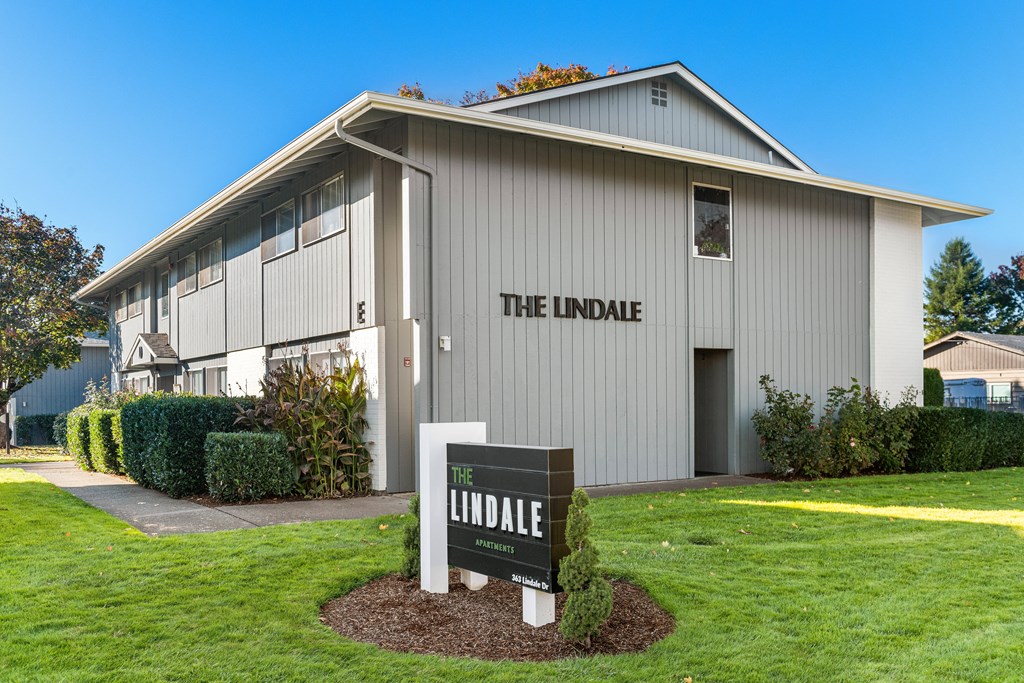 A grey building with a sign that says "The Lindale" in front of it.