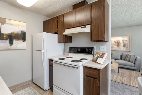 A small kitchen with a white fridge and stove top oven.