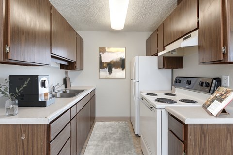 A kitchen with brown cabinets and white appliances.