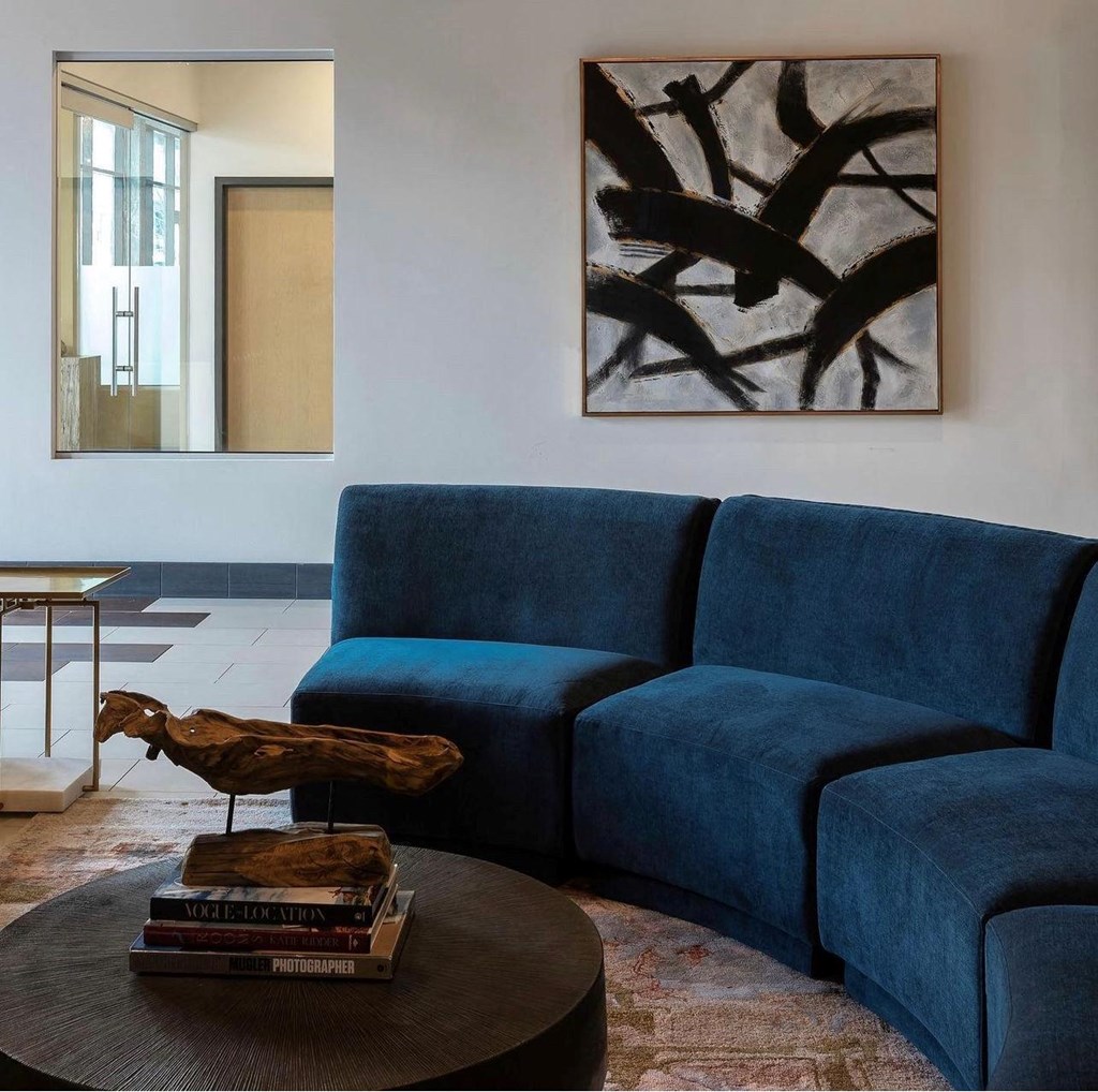 a blue couch in a living room with a table and a bird statue
