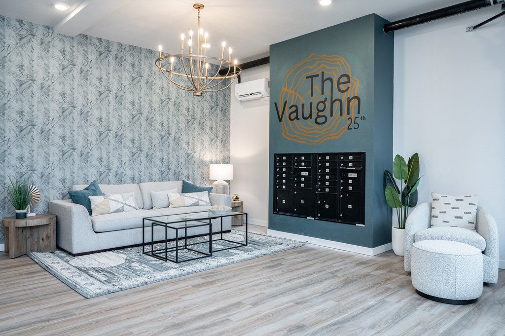 a living room with a large mural on the wall and a couch and chair in front of