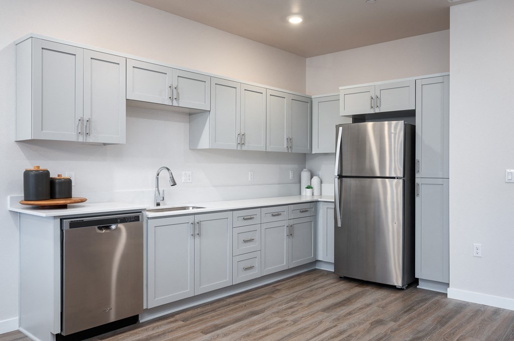 a kitchen with white cabinets and stainless steel appliances
