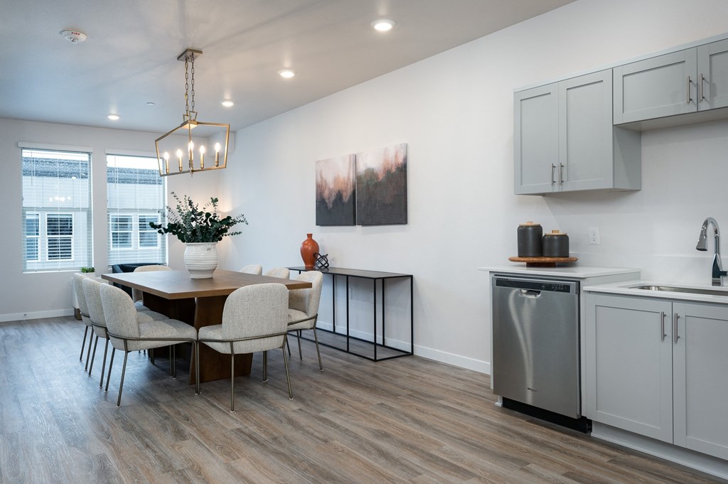 a kitchen and dining room area with a table and chairs and a stainless steel dishwasher