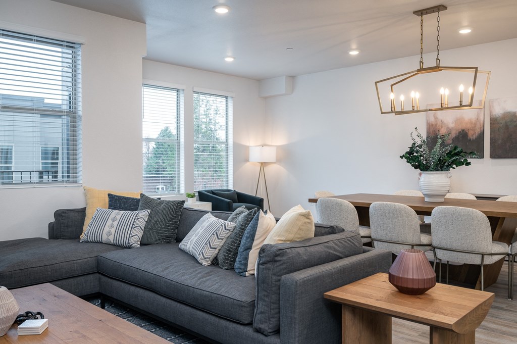 a living room and dining room with white walls and wood floors
