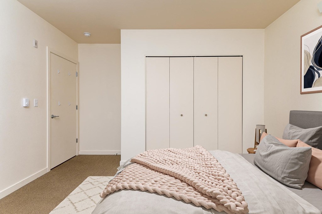 a bedroom with a large bed and white closets