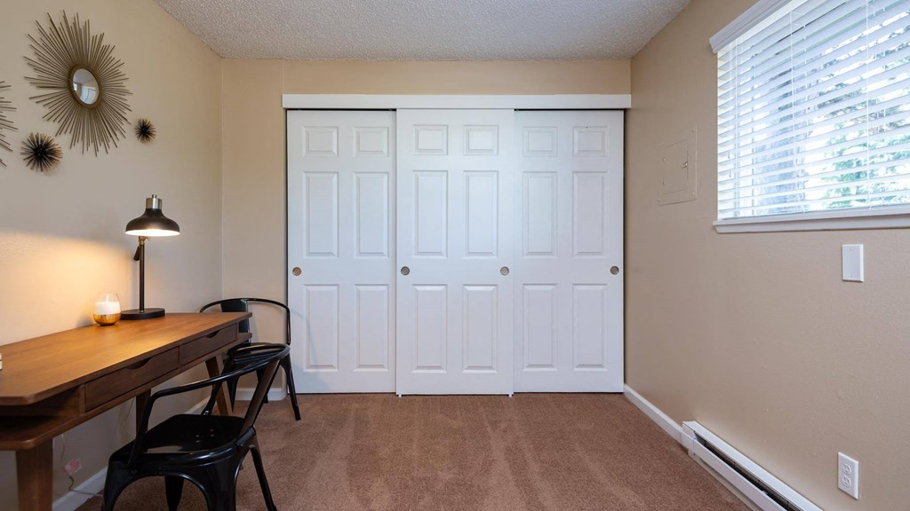a room with two closets and a table and chairs