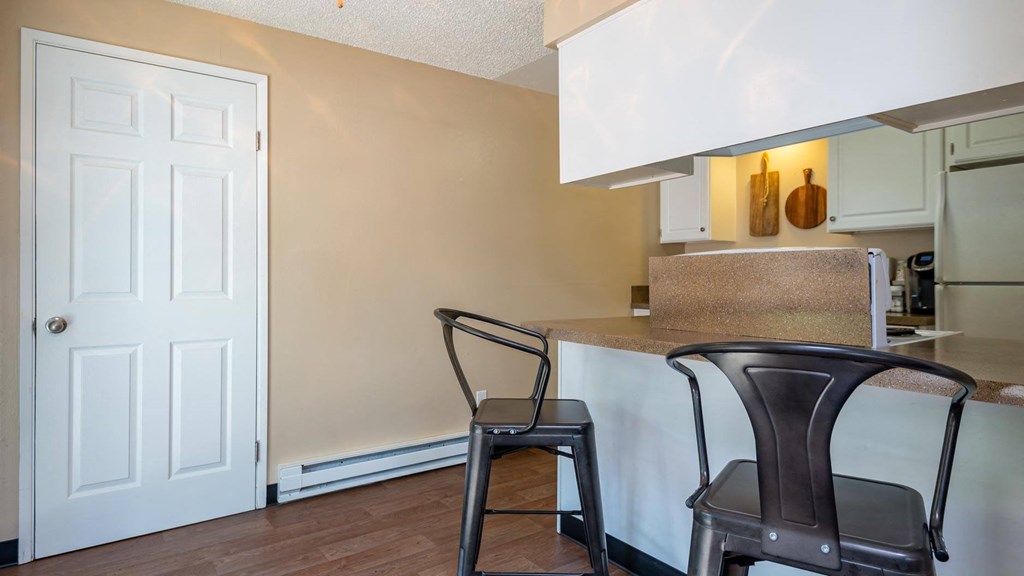 a kitchen with two stools in front of a counter top