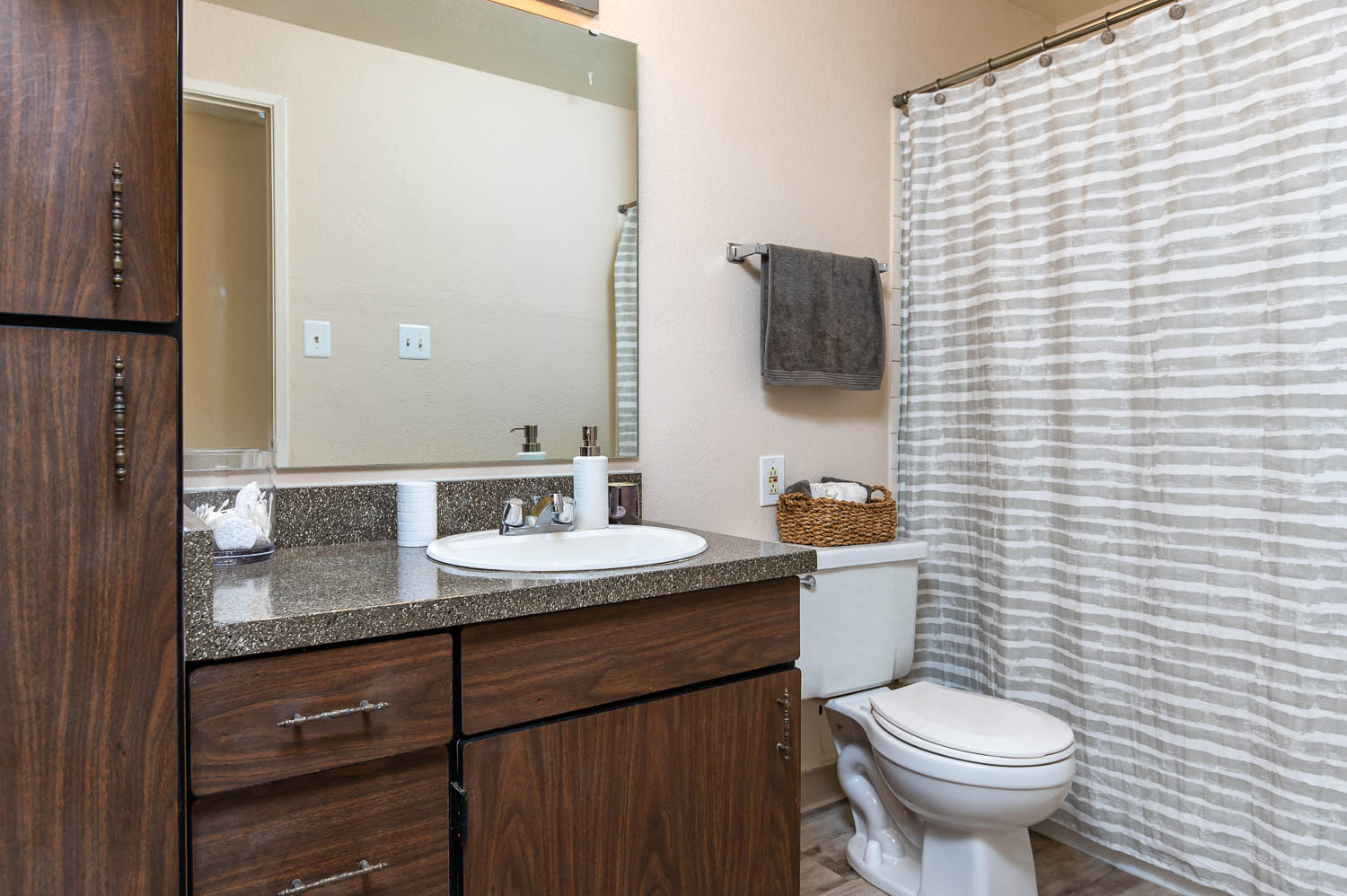 Model Bathroom with wood cabinetry and large mirror