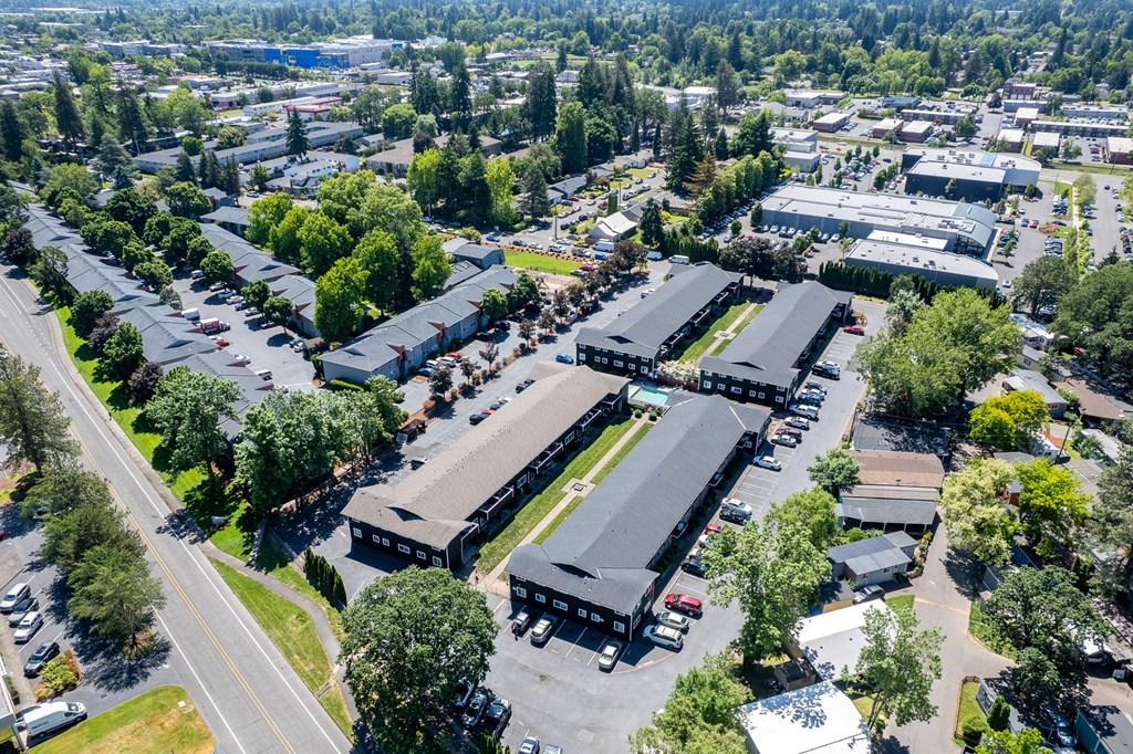 An aerial view of residential area with multiple buildings and parking lots.