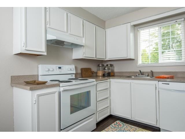 a white kitchen with white appliances and white cabinets