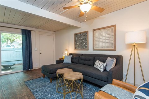 a living room with a couch and a ceiling fan