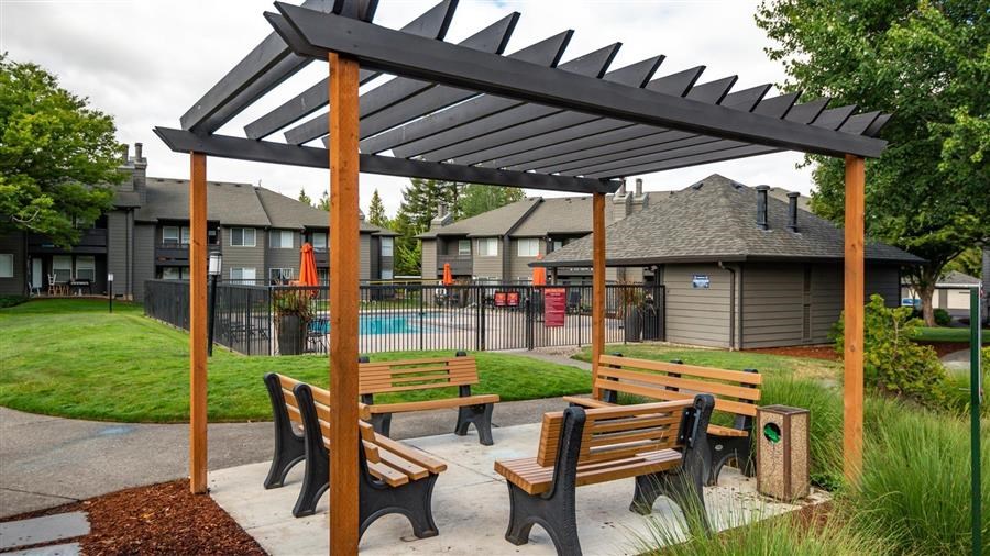 a picnic area with benches and a pergola