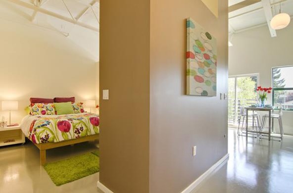 a bedroom with a bed and a painting on the wall