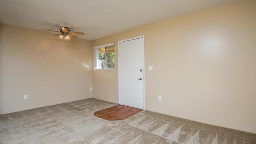 a empty room with a ceiling fan and a door