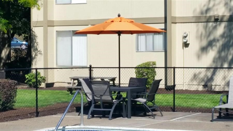 a table with an umbrella and chairs in a pool
