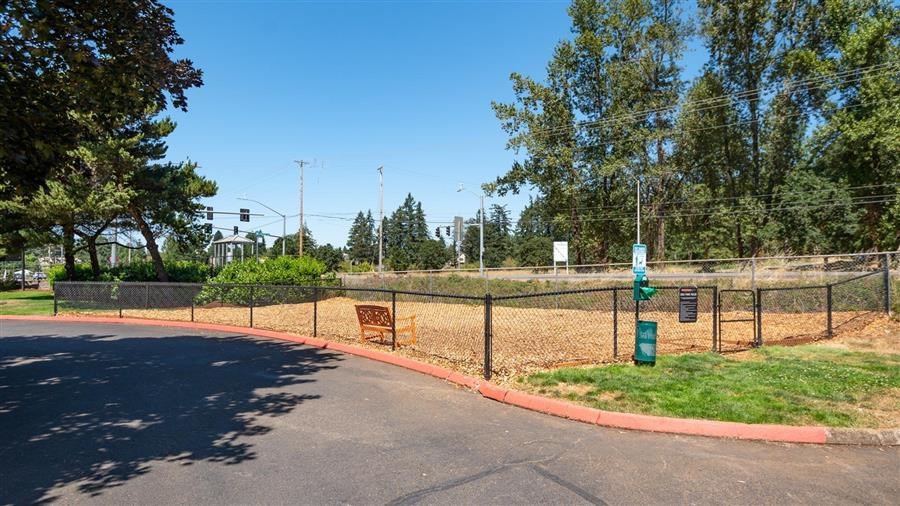 a park with a fenced in area and trees