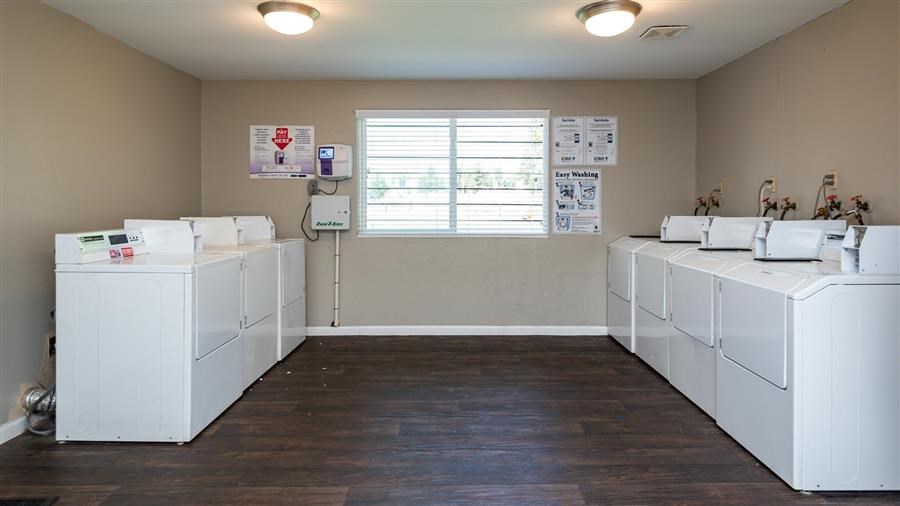 a group of white washer and dryers in a room