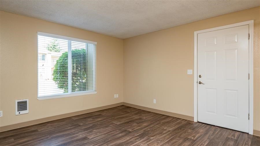 an empty room with a white door and a window