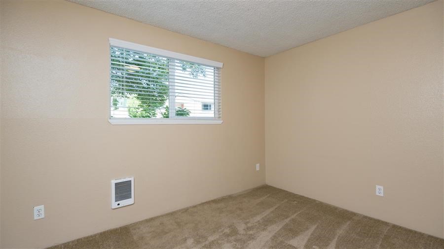 an empty room with a window and a carpet