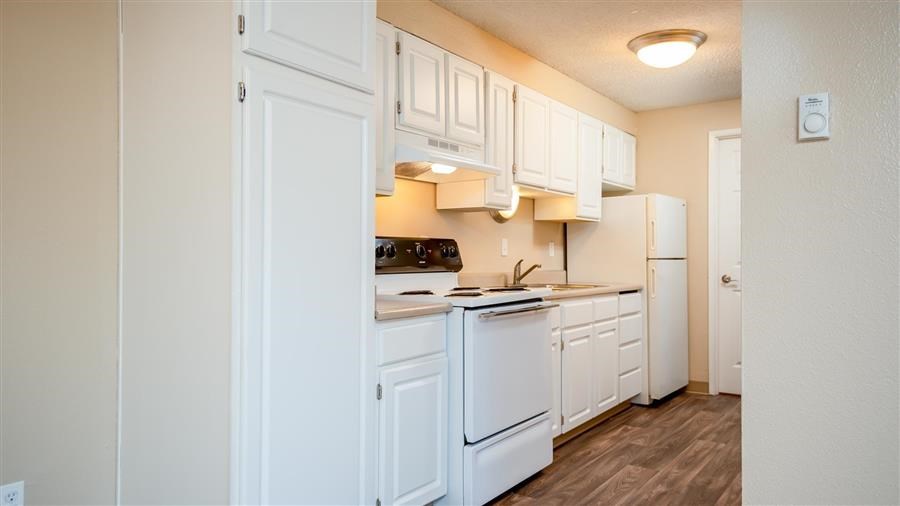 a white kitchen with white cabinets and white appliances