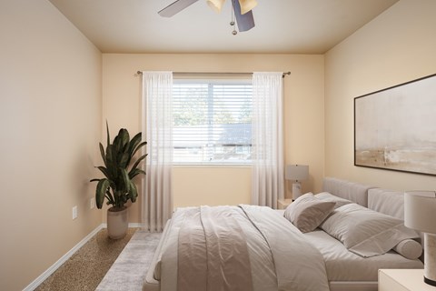 A bedroom with a large bed and a ceiling fan.