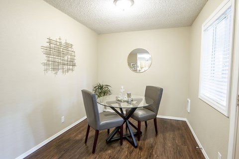 A dining room with a table and chairs.