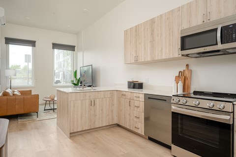 A modern kitchen with wooden cabinets and stainless steel appliances.