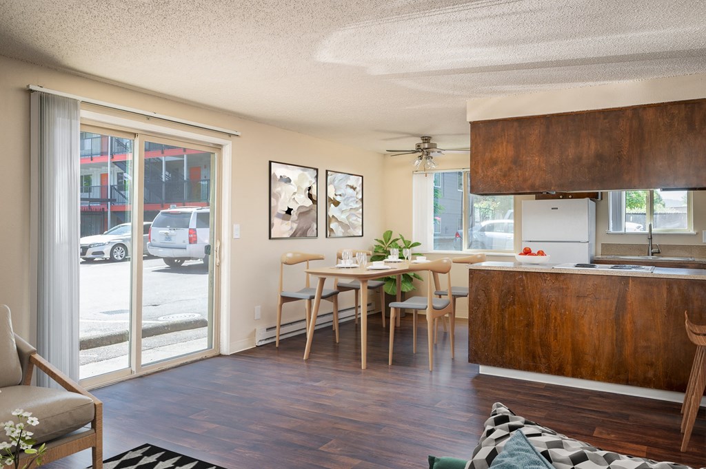 the view of a living room and a kitchen with a table and chairs