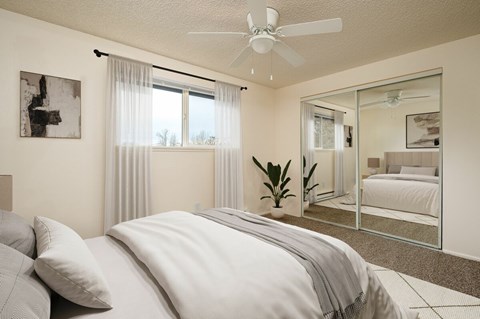 A bedroom with a large bed and a ceiling fan.