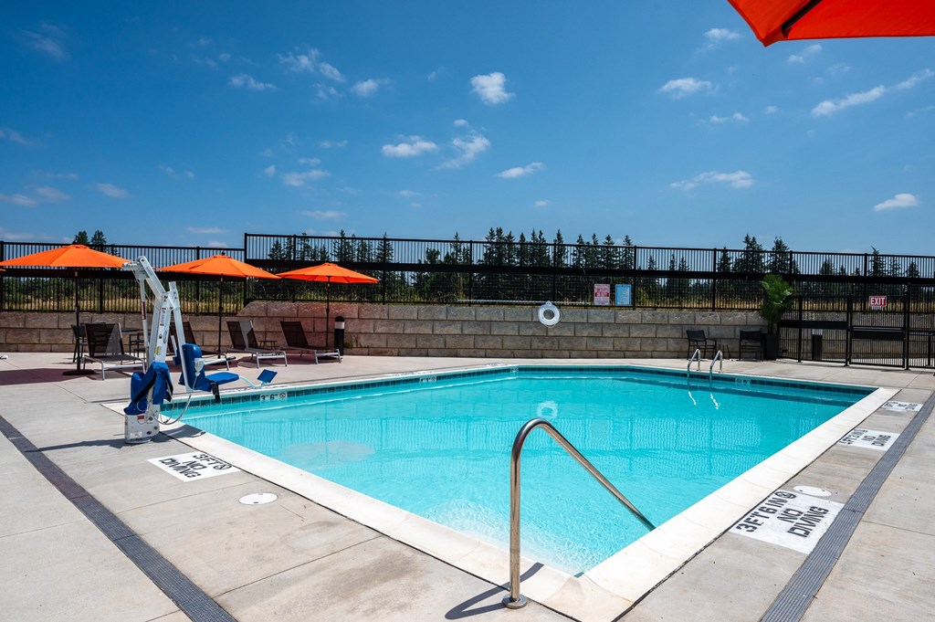 a swimming pool on a sunny day with umbrellas