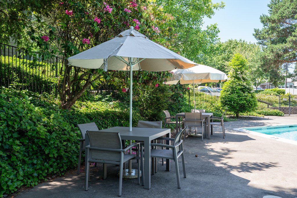 A patio with a table and chairs under an umbrella.