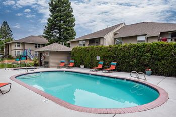 a swimming pool with a house in the background