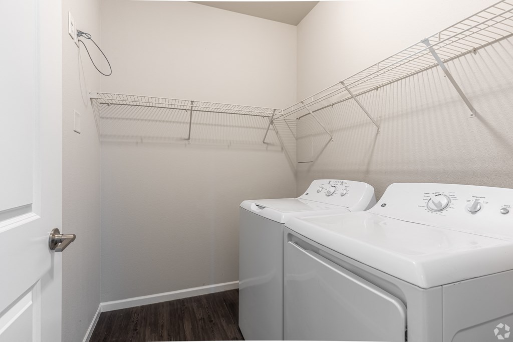 a laundry room with a washer and dryer and a closet with a rack