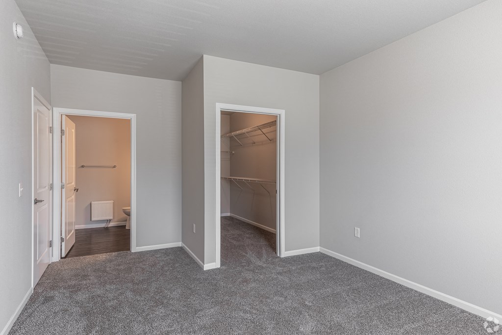 a bedroom with a closet and a door to a bathroom