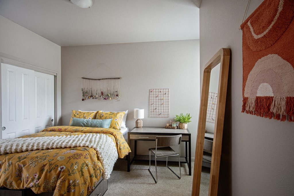 The Quad | Fully Furnished Bedroom The Quad near OSU - Apartments in Corvallis, OR with wall to wall carpet, white walls, and access to the bathroom