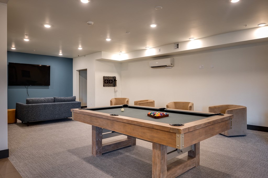 a games room with a pool table and a tv