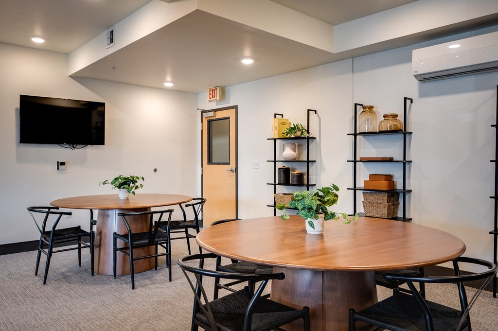 a dining room with tables and chairs and a tv on the wall