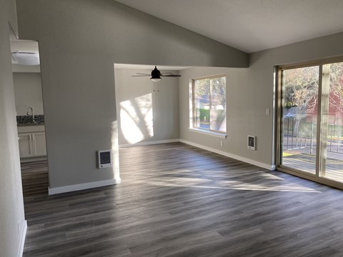 A spacious room with a ceiling fan and sliding glass doors.