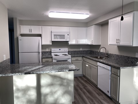 A kitchen with white appliances and cabinets.