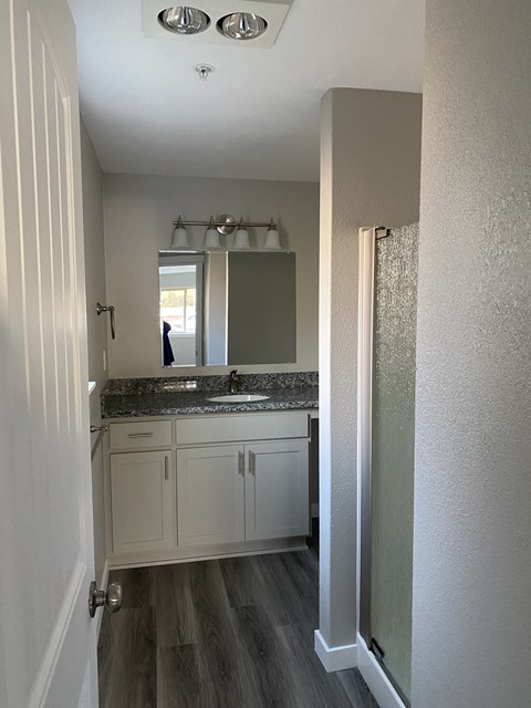 A bathroom with a sink, mirror, and cabinets.