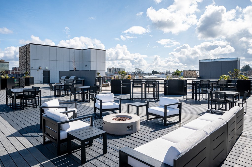 a roof top patio with furniture and a fire pit