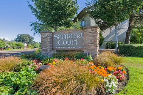 A sign that says "Santana Court" in front of a building.