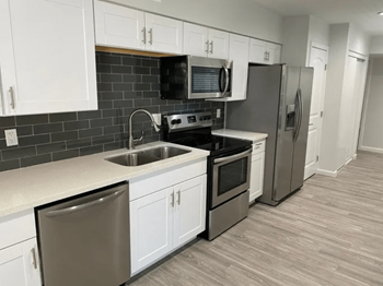 a kitchen with stainless steel appliances and white cabinets