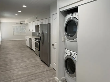 a washer and dryer in a laundry room next to a kitchen