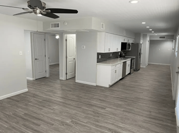 a kitchen and a living room with a wooden floor