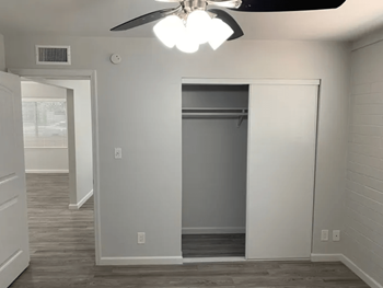 a renovated living room with a closet and a ceiling fan