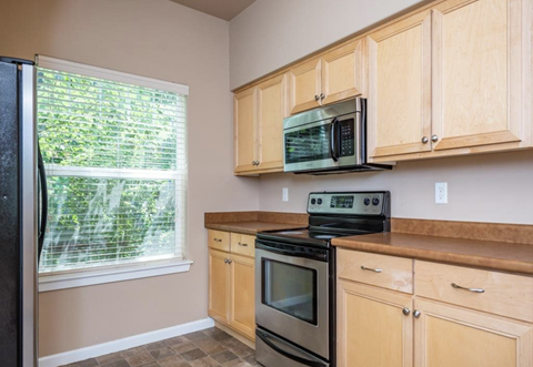 Southside Townhome | Kitchen with Wood Cabinetry and Stainless Steel Appliances